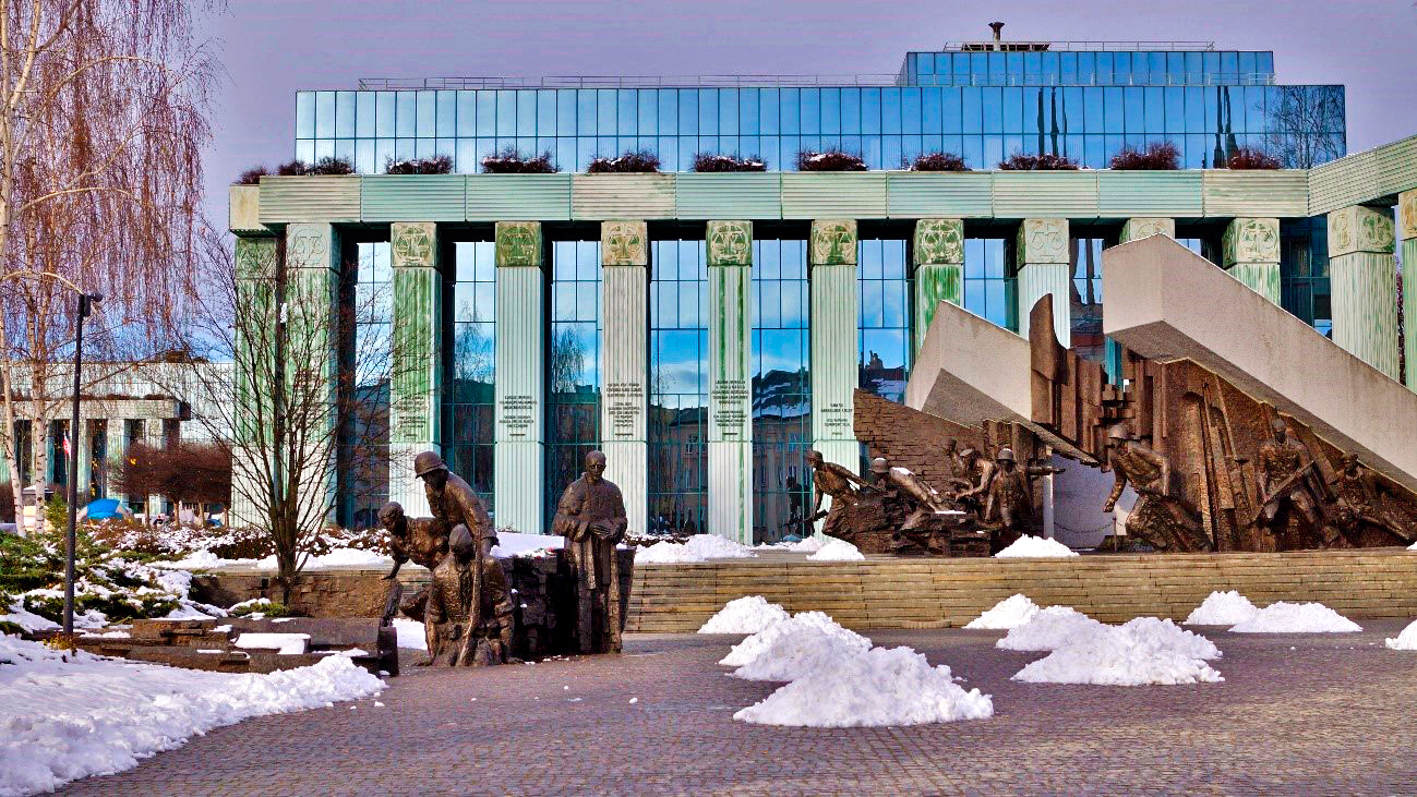 Topo do monumento da Revolta de Varsóvia, com o prédio do Supremo Tribunal ao fundo