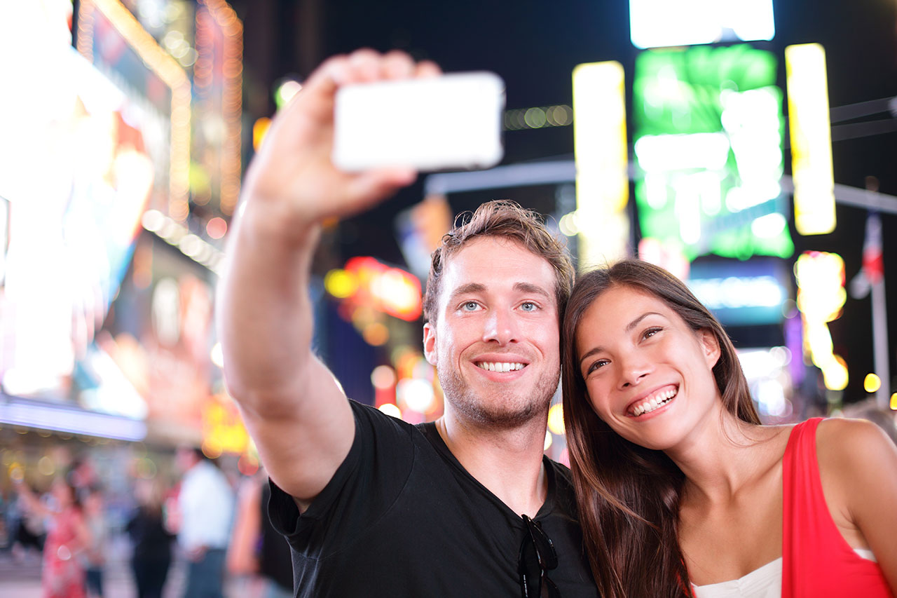 Casal tirando selfie na Times Square na viagem em Nova York
