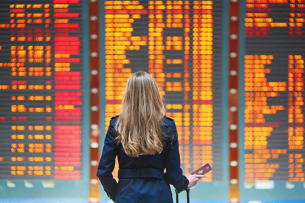 Viajante vendo o painel do aeroporto