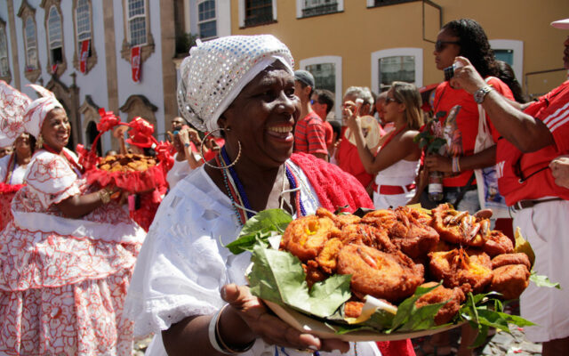 Baiana carregando acarajé que é um dos pratos típicos da Bahia
